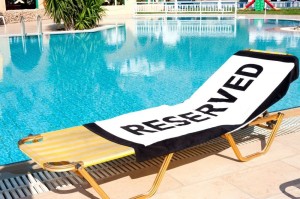 Reserveren van bedjes bij het zwembad op vakantie.